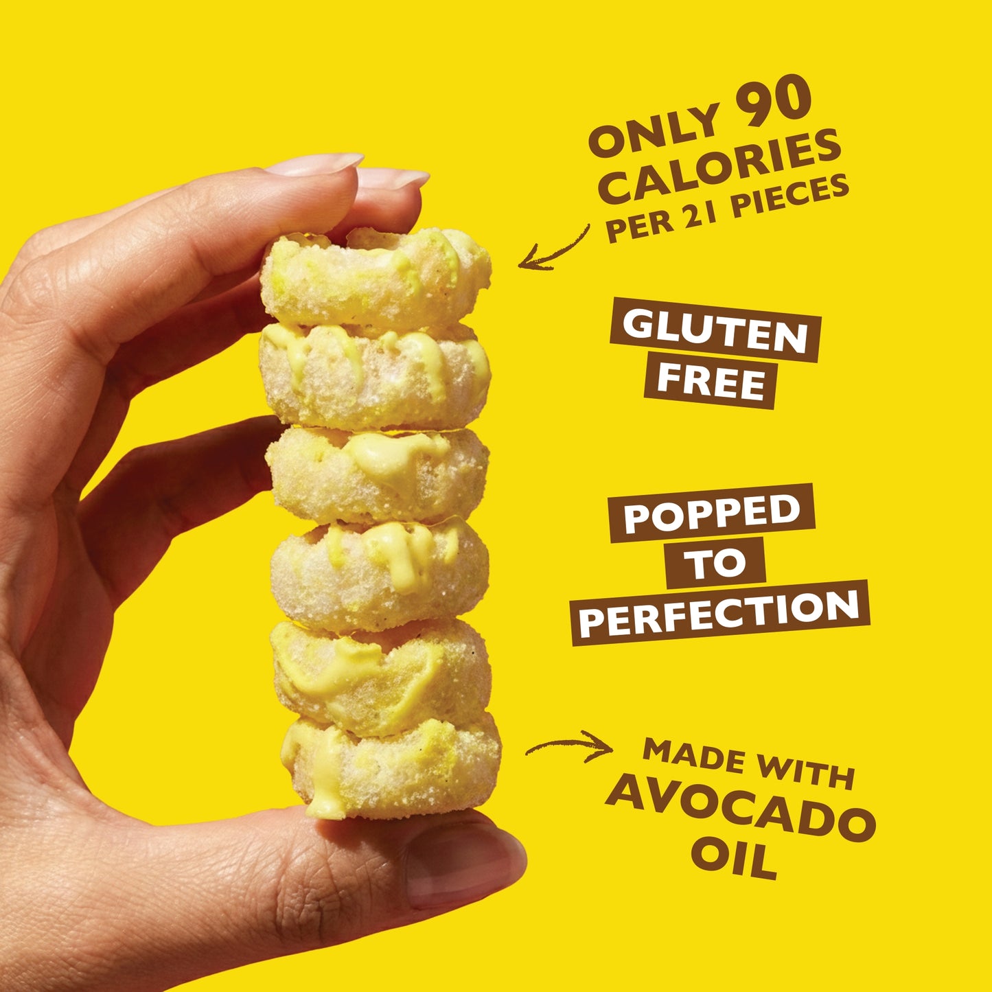 Stack of gluten-free lemon cake bites with white drizzle held in a hand